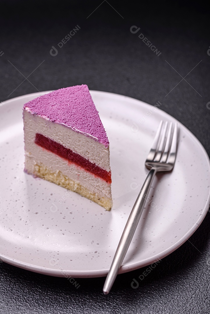 Delicioso bolo de mousse doce fresco com recheio de frutas vermelhas coberto com cobertura de veludo rosa sobre fundo escuro de concreto