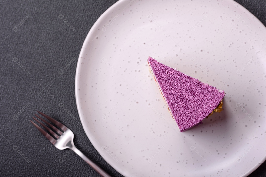 Delicioso bolo de mousse doce fresco com recheio de frutas vermelhas coberto com cobertura de veludo rosa sobre fundo escuro de concreto