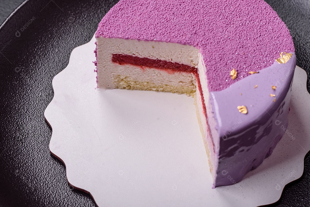 Delicioso bolo de mousse doce fresco com recheio de frutas vermelhas coberto com cobertura de veludo rosa sobre fundo escuro de concreto