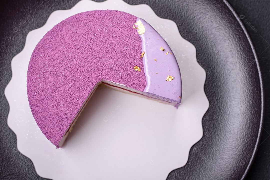 Delicioso bolo de mousse doce fresco com recheio de frutas vermelhas coberto com cobertura de veludo rosa sobre fundo escuro de concreto