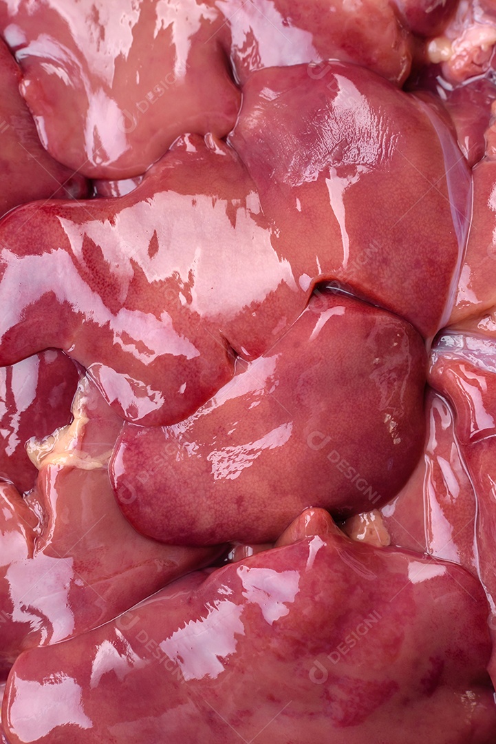 Frango cru fresco ou fígado de peru em uma placa cerâmica com sal, especiarias e ervas sobre um fundo escuro de concreto