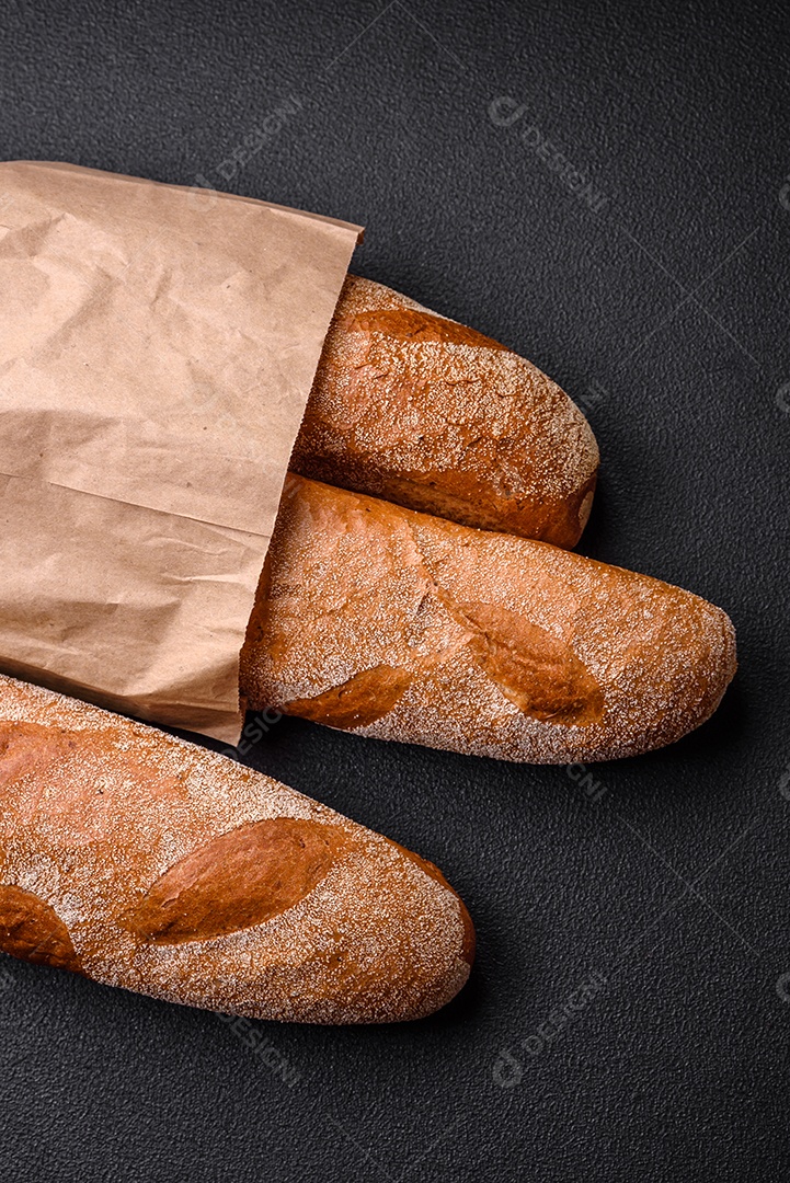 Pão baguete francês sobre um fundo de concreto texturizado escuro. Fazendo uma deliciosa bruscheta em casa