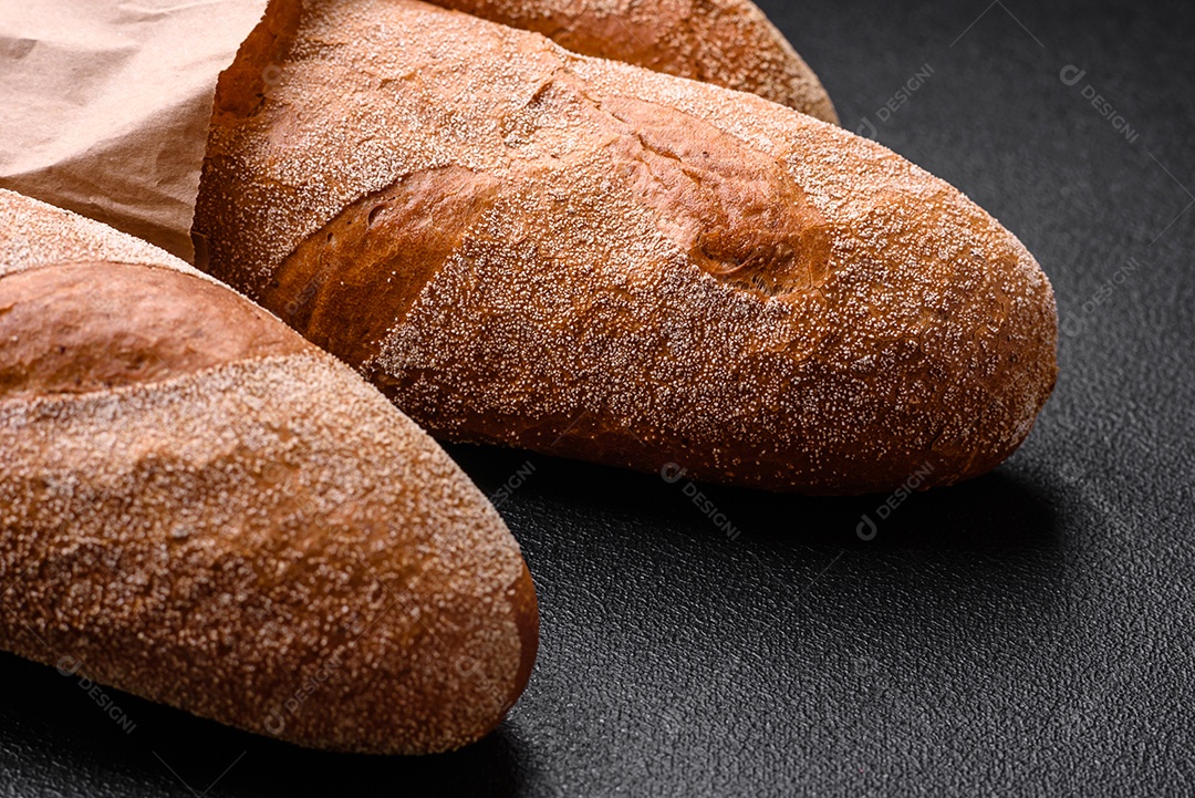 Pão baguete francês sobre um fundo de concreto texturizado escuro. Fazendo uma deliciosa bruscheta em casa