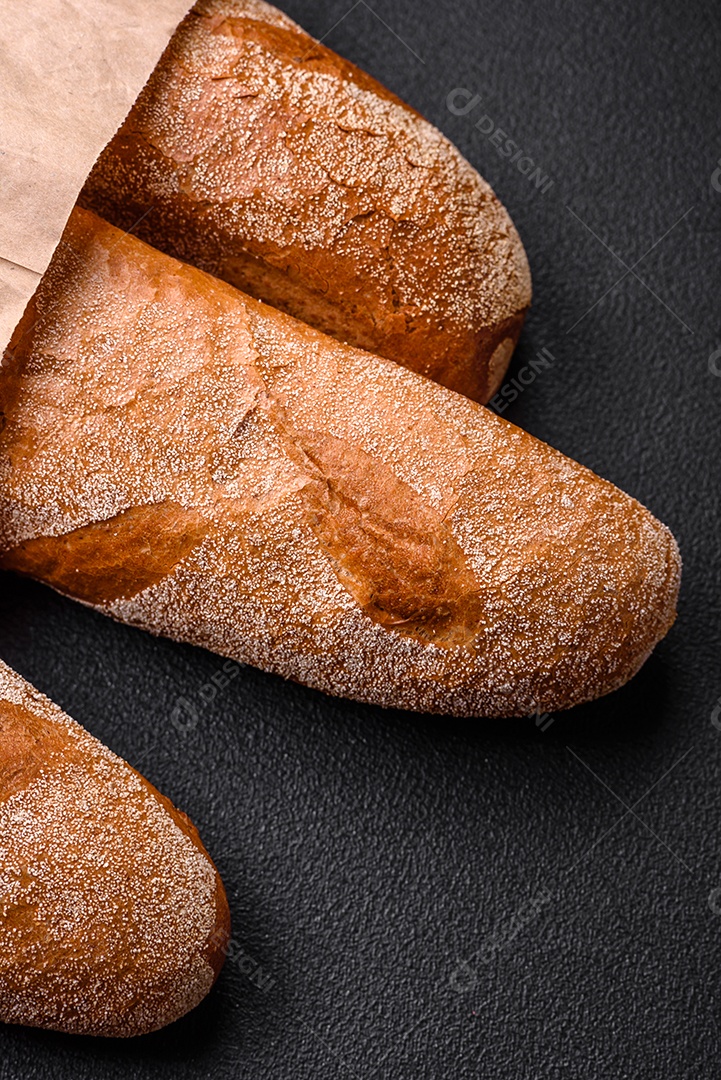 Pão baguete francês sobre um fundo de concreto texturizado escuro. Fazendo uma deliciosa bruscheta em casa