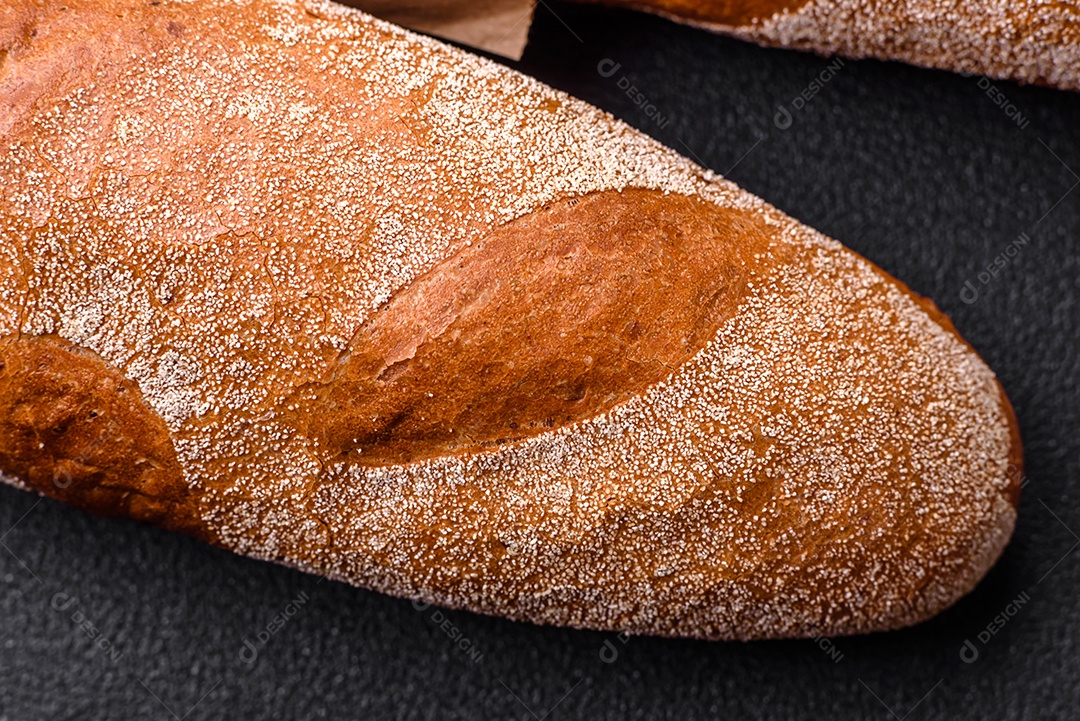 Pão baguete francês sobre um fundo de concreto texturizado escuro. Fazendo uma deliciosa bruscheta em casa