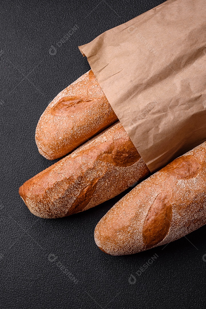 Pão baguete francês sobre um fundo de concreto texturizado escuro. Fazendo uma deliciosa bruscheta em casa