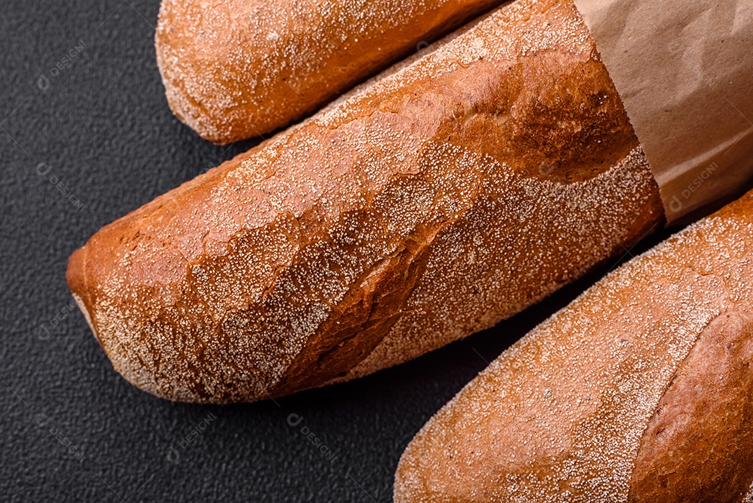 Pão baguete francês sobre um fundo de concreto texturizado escuro. Fazendo uma deliciosa bruscheta em casa