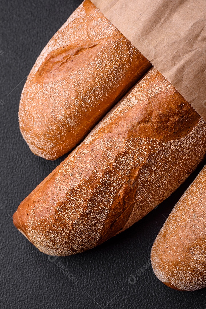 Pão baguete francês sobre um fundo de concreto texturizado escuro. Fazendo uma deliciosa bruscheta em casa