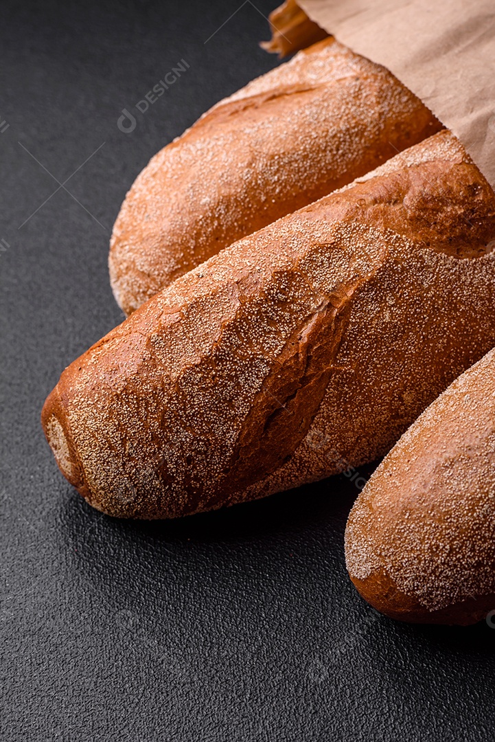 Pão baguete francês sobre um fundo de concreto texturizado escuro. Fazendo uma deliciosa bruscheta em casa