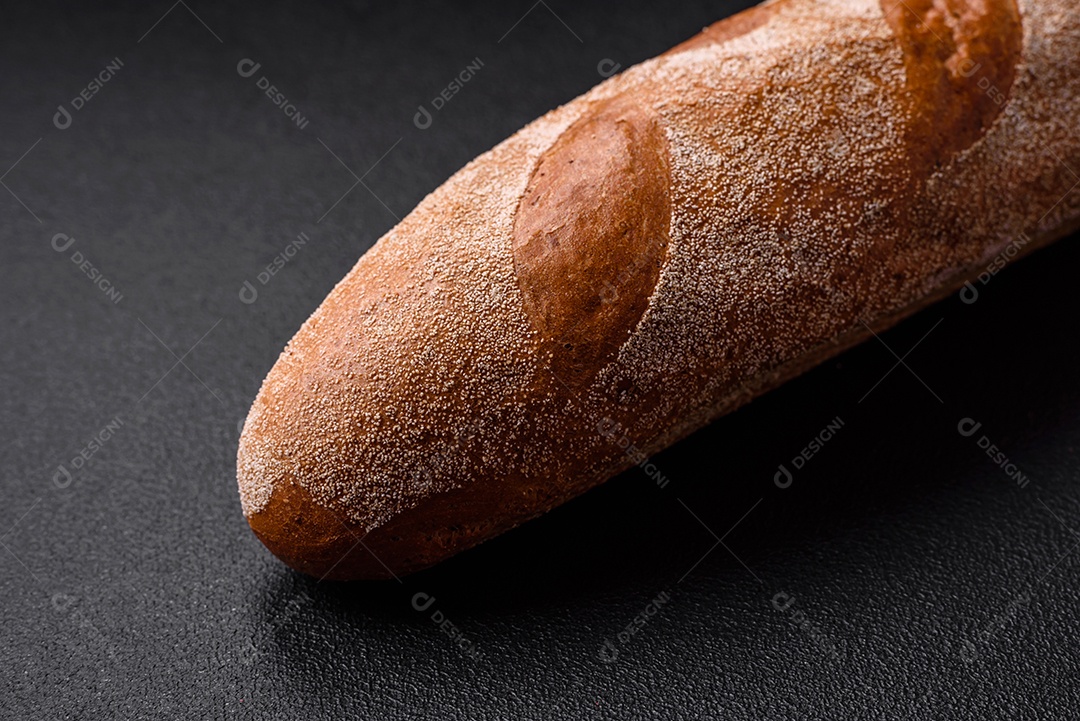 Pão baguete francês sobre um fundo de concreto texturizado escuro. Fazendo uma deliciosa bruscheta em casa