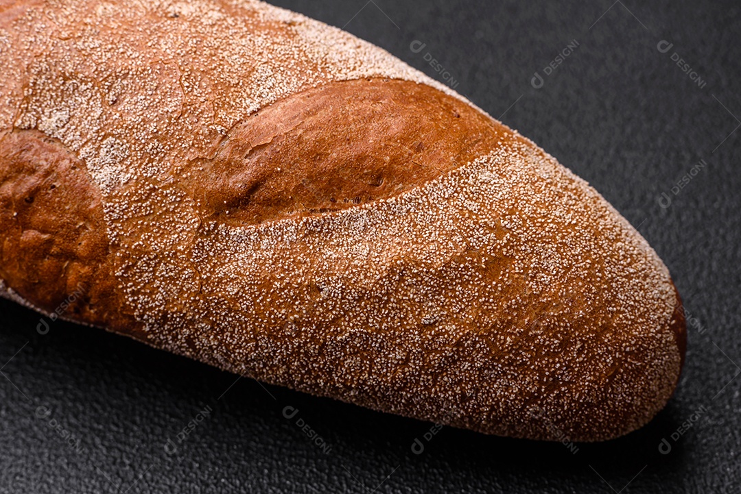 Pão baguete francês sobre um fundo de concreto texturizado escuro. Fazendo uma deliciosa bruscheta em casa