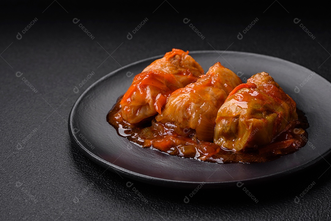 Delicioso dolma em molho de tomate com cenoura, cebola, sal, especiarias e ervas sobre um fundo escuro de concreto