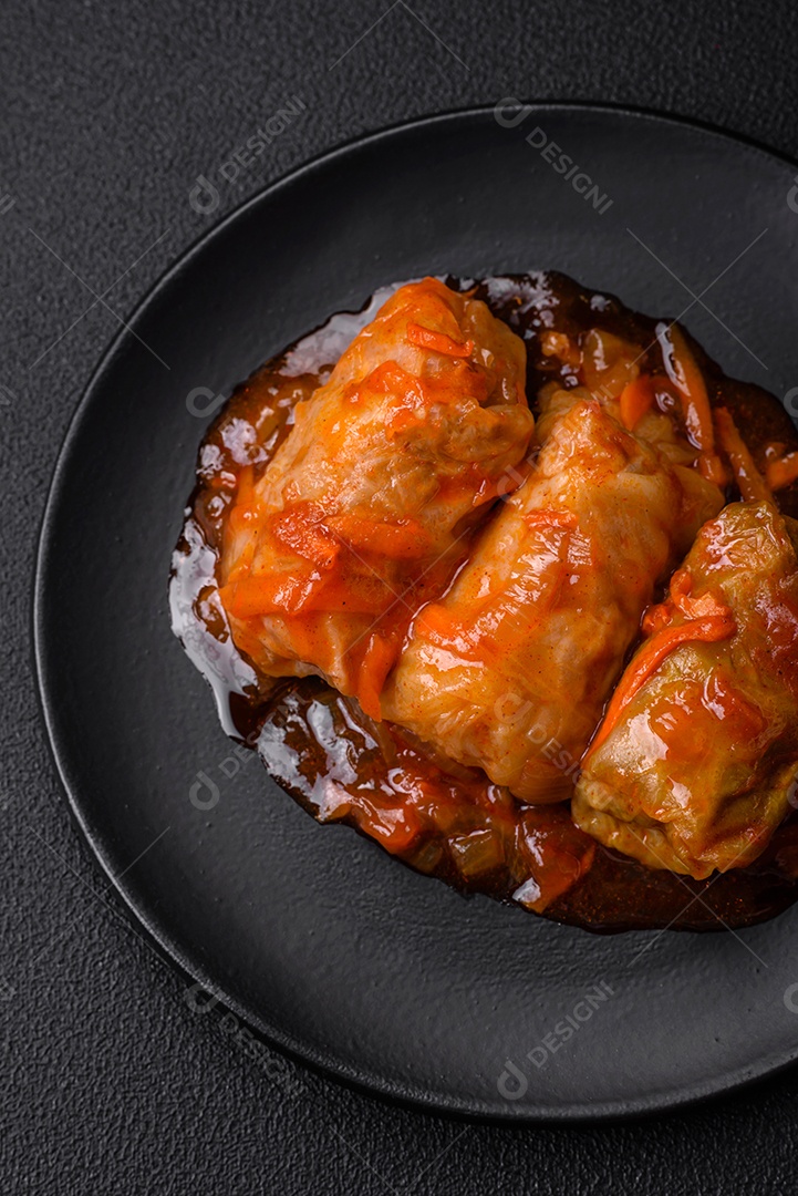 Delicioso dolma em molho de tomate com cenoura, cebola, sal, especiarias e ervas sobre um fundo escuro de concreto