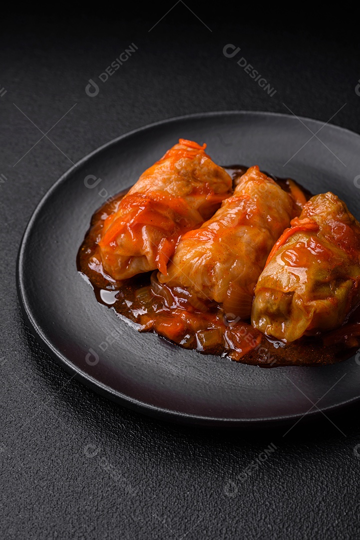 Delicioso dolma em molho de tomate com cenoura, cebola, sal, especiarias e ervas sobre um fundo escuro de concreto