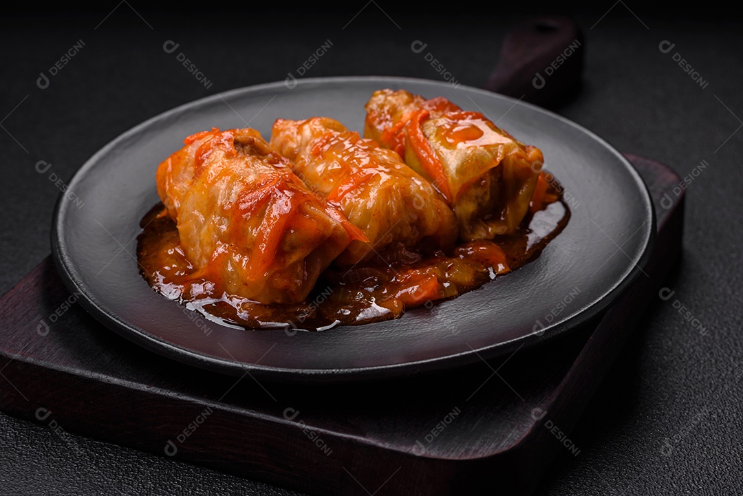 Delicioso dolma em molho de tomate com cenoura, cebola, sal, especiarias e ervas sobre um fundo escuro de concreto