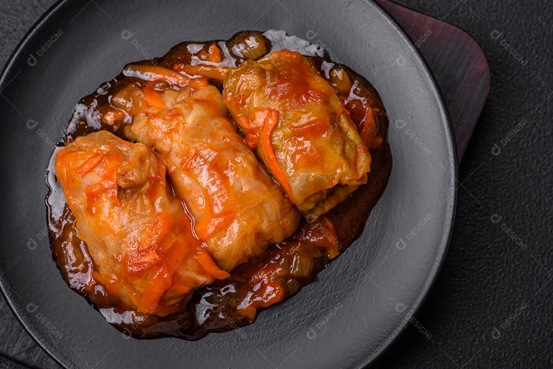 Delicioso dolma em molho de tomate com cenoura, cebola, sal, especiarias e ervas sobre um fundo escuro de concreto