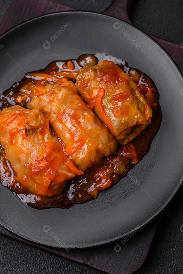 Delicioso dolma em molho de tomate com cenoura, cebola, sal, especiarias e ervas sobre um fundo escuro de concreto