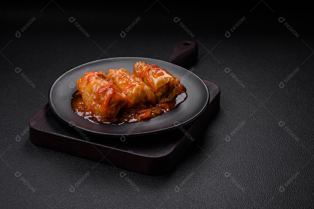 Delicioso dolma em molho de tomate com cenoura, cebola, sal, especiarias e ervas sobre um fundo escuro de concreto