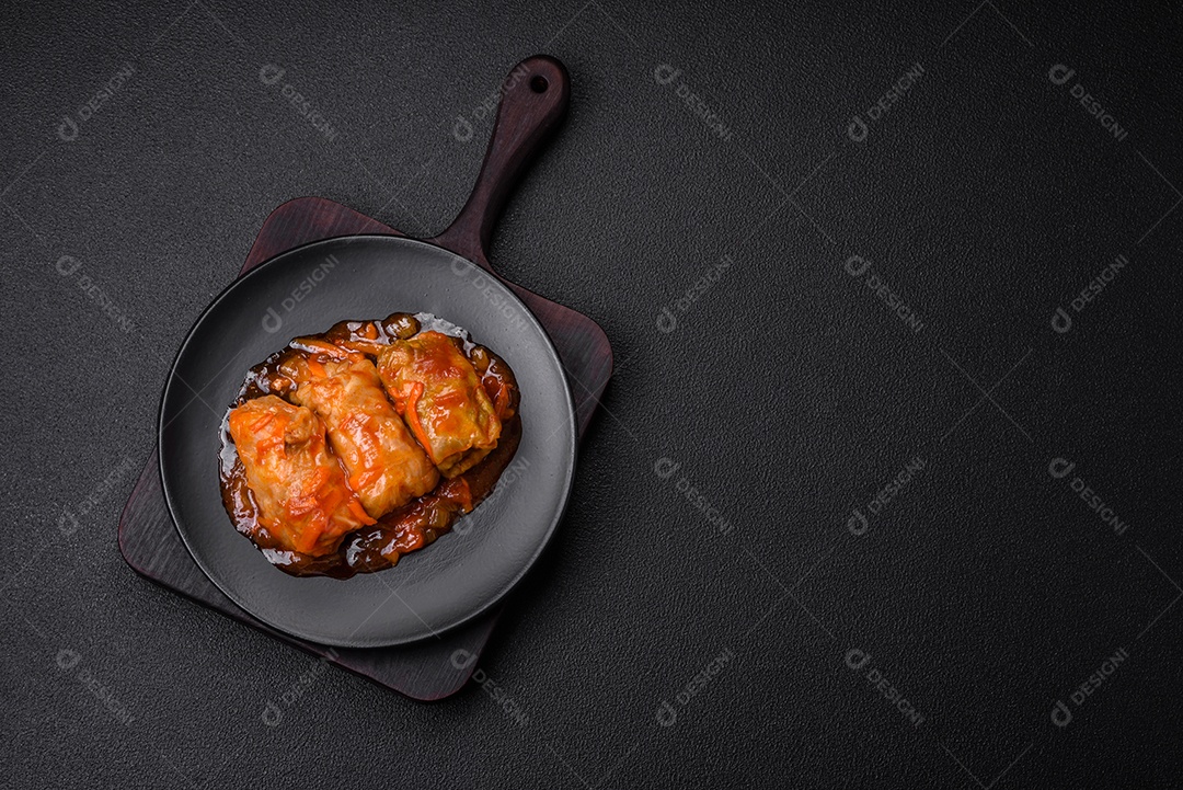 Delicioso dolma em molho de tomate com cenoura, cebola, sal, especiarias e ervas sobre um fundo escuro de concreto