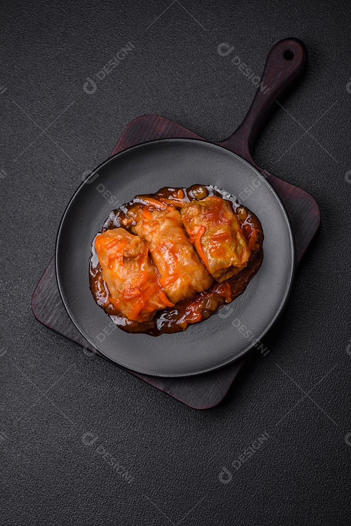 Delicioso dolma em molho de tomate com cenoura, cebola, sal, especiarias e ervas sobre um fundo escuro de concreto