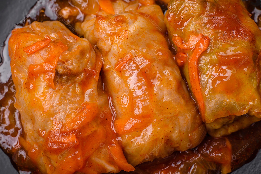 Delicioso dolma em molho de tomate com cenoura, cebola, sal, especiarias e ervas sobre um fundo escuro de concreto