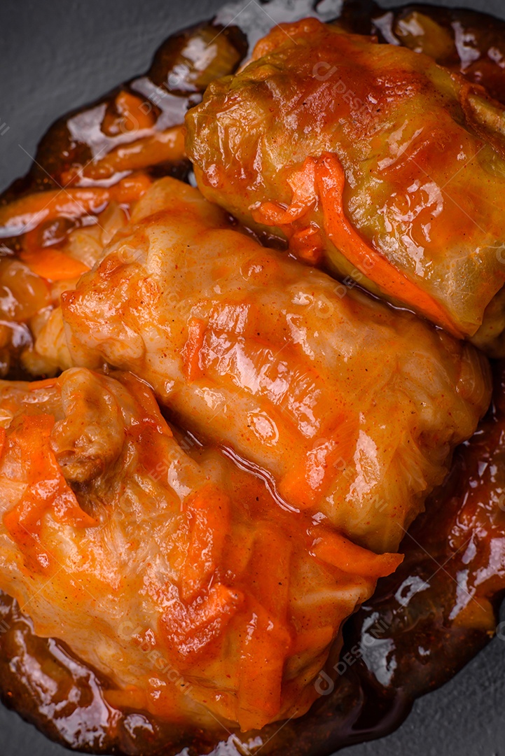 Delicioso dolma em molho de tomate com cenoura, cebola, sal, especiarias e ervas sobre um fundo escuro de concreto