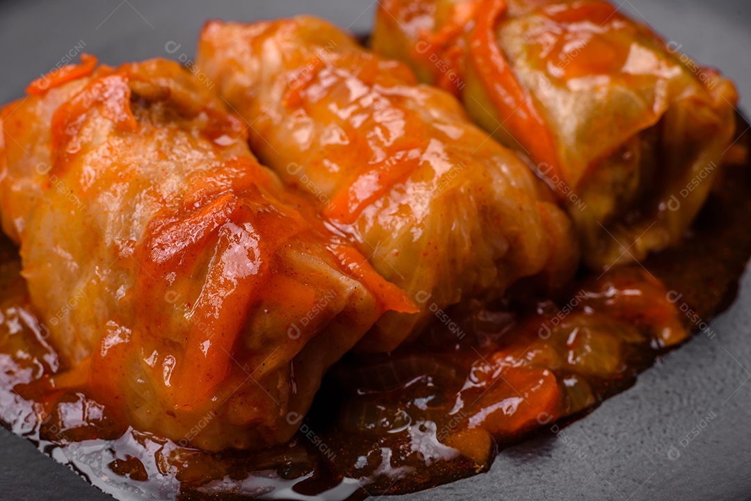 Delicioso dolma em molho de tomate com cenoura, cebola, sal, especiarias e ervas sobre um fundo escuro de concreto