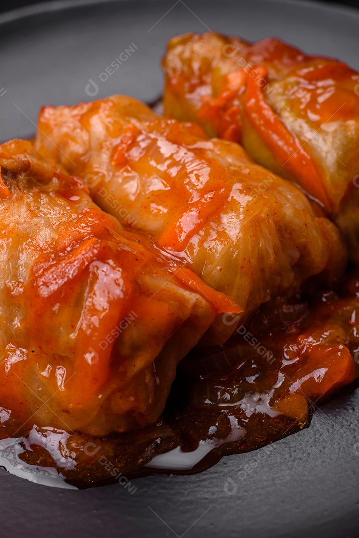 Delicioso dolma em molho de tomate com cenoura, cebola, sal, especiarias e ervas sobre um fundo escuro de concreto