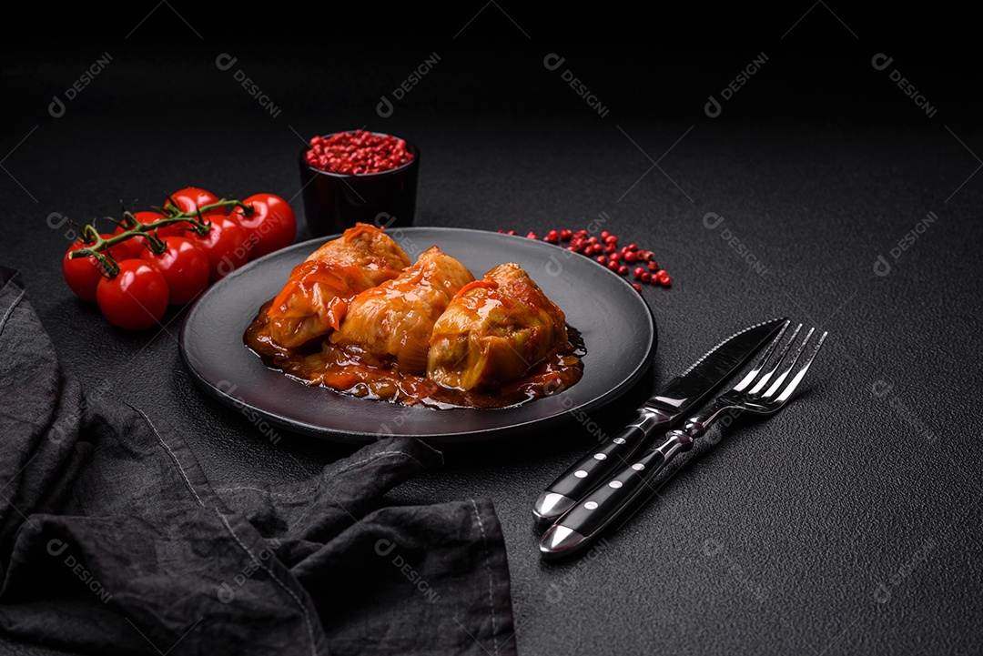 Delicioso dolma em molho de tomate com cenoura, cebola, sal, especiarias e ervas sobre um fundo escuro de concreto