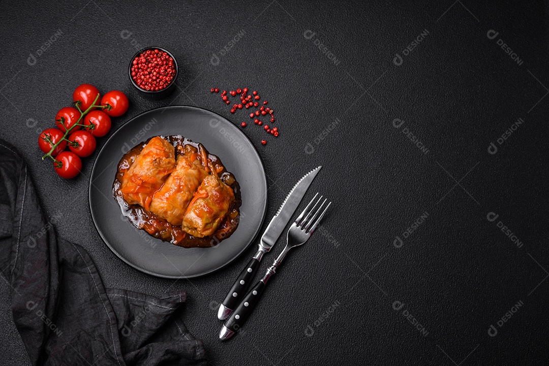 Delicioso dolma em molho de tomate com cenoura, cebola, sal, especiarias e ervas sobre um fundo escuro de concreto