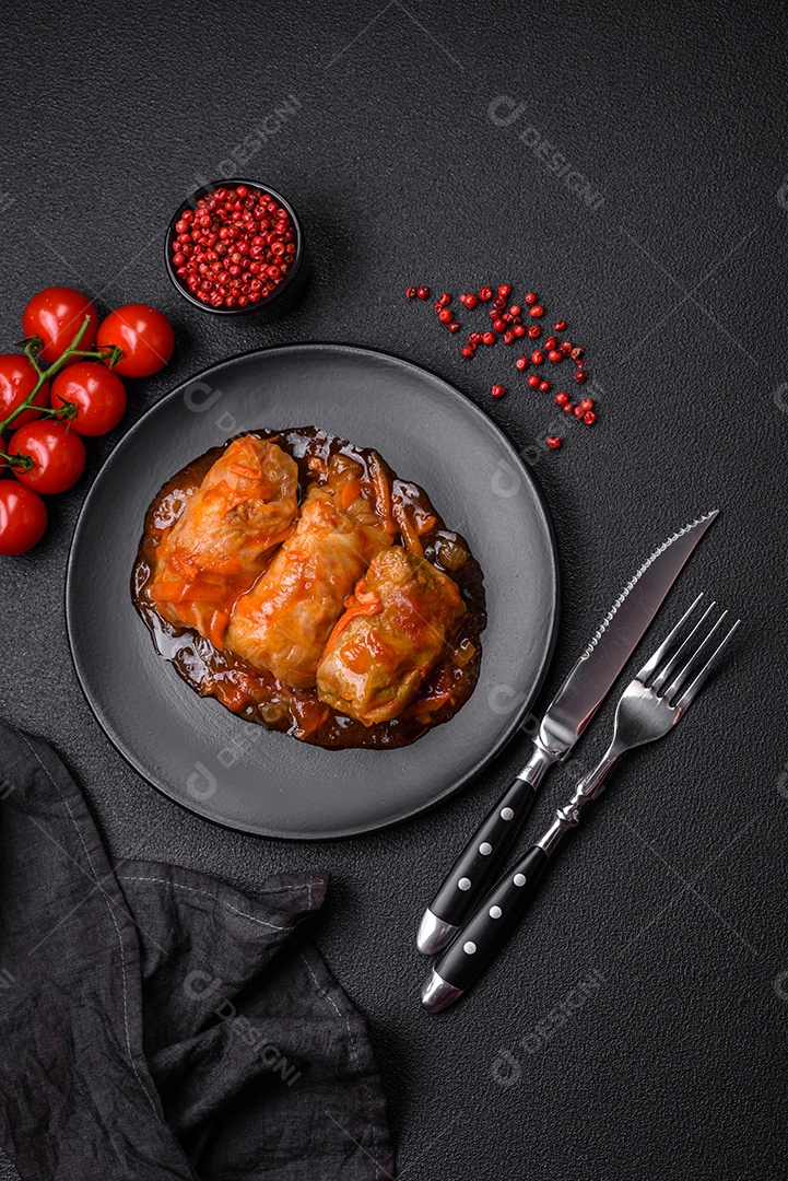 Delicioso dolma em molho de tomate com cenoura, cebola, sal, especiarias e ervas sobre um fundo escuro de concreto