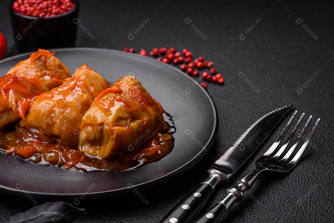 Delicioso dolma em molho de tomate com cenoura, cebola, sal, especiarias e ervas sobre um fundo escuro de concreto