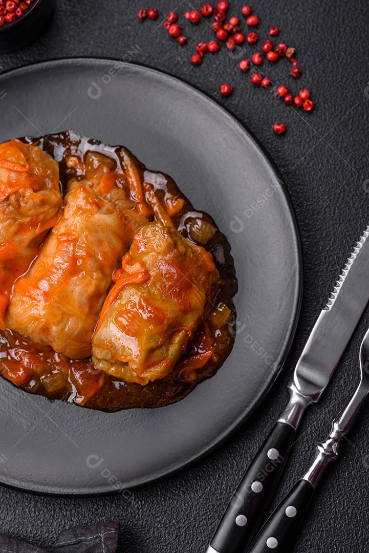 Delicioso dolma em molho de tomate com cenoura, cebola, sal, especiarias e ervas sobre um fundo escuro de concreto