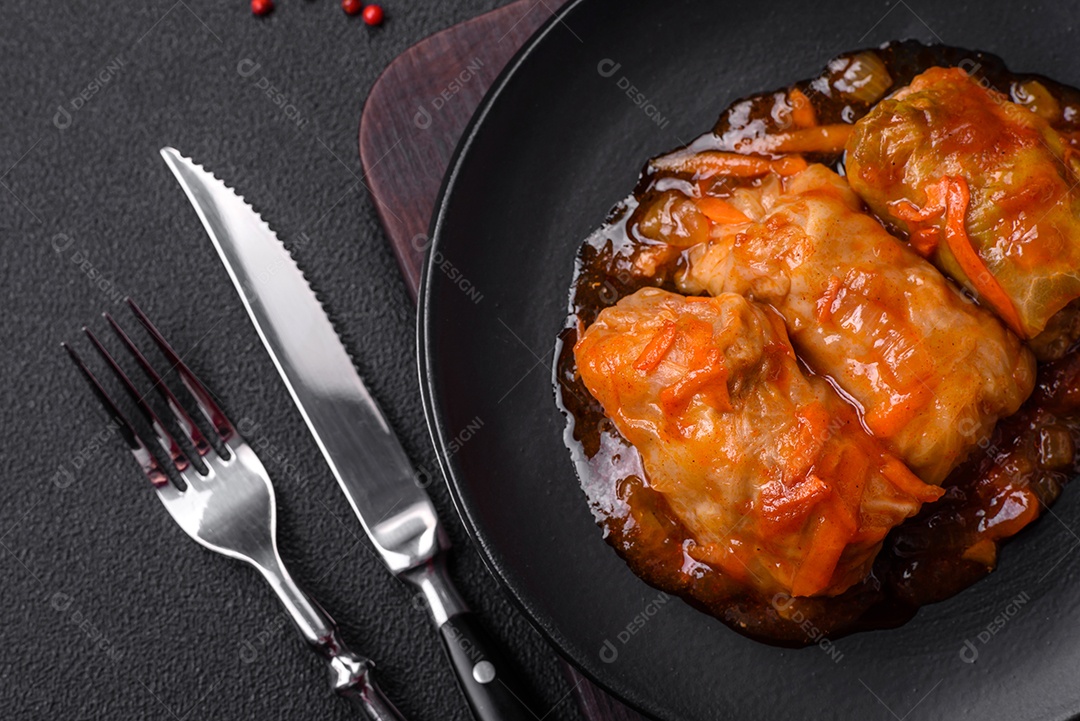 Delicioso dolma em molho de tomate com cenoura, cebola, sal, especiarias e ervas sobre um fundo escuro de concreto