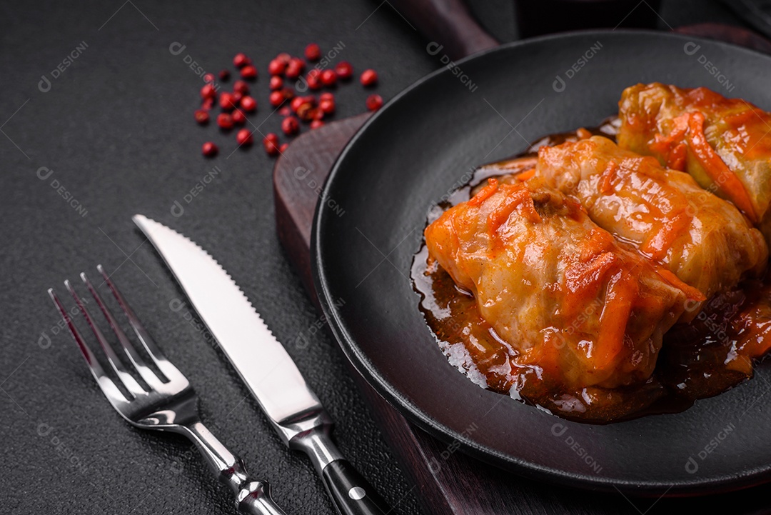 Delicioso dolma em molho de tomate com cenoura, cebola, sal, especiarias e ervas sobre um fundo escuro de concreto