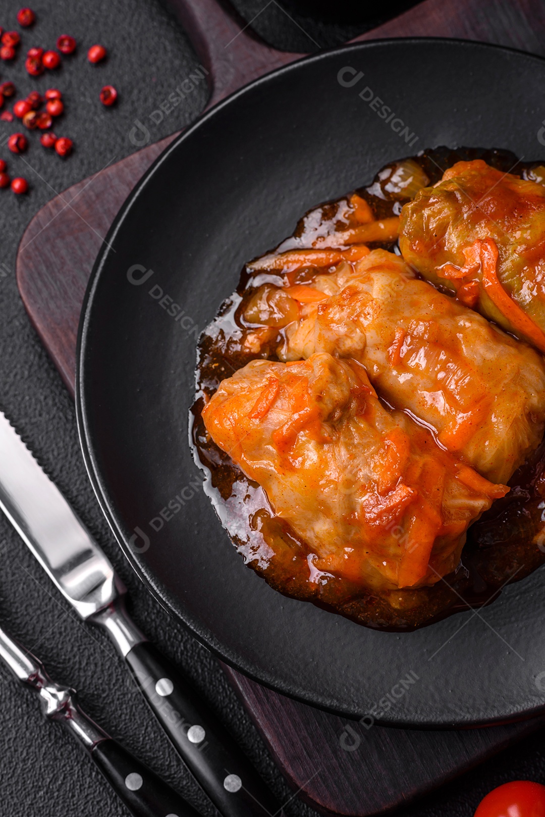 Delicioso dolma em molho de tomate com cenoura, cebola, sal, especiarias e ervas sobre um fundo escuro de concreto