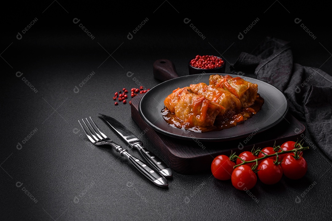 Delicioso dolma em molho de tomate com cenoura, cebola, sal, especiarias e ervas sobre um fundo escuro de concreto