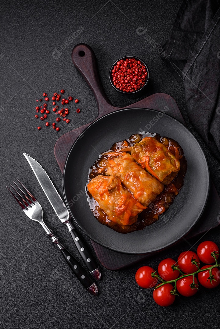 Delicioso dolma em molho de tomate com cenoura, cebola, sal, especiarias e ervas sobre um fundo escuro de concreto