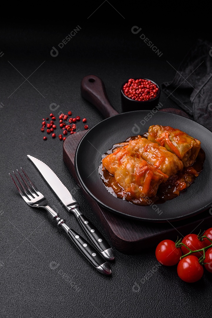 Delicioso dolma em molho de tomate com cenoura, cebola, sal, especiarias e ervas sobre um fundo escuro de concreto