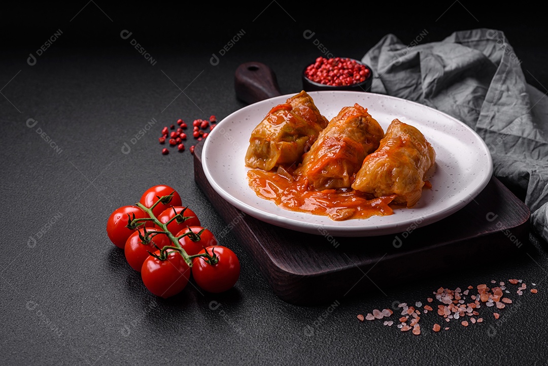 Delicioso dolma em molho de tomate com cenoura, cebola, sal, especiarias e ervas sobre um fundo escuro de concreto