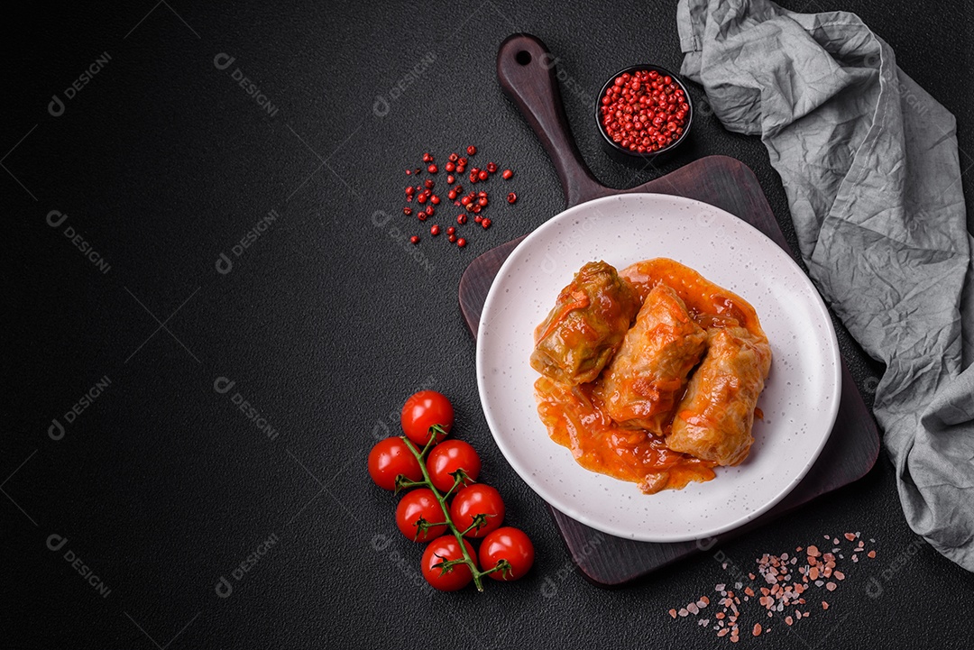 Delicioso dolma em molho de tomate com cenoura, cebola, sal, especiarias e ervas sobre um fundo escuro de concreto