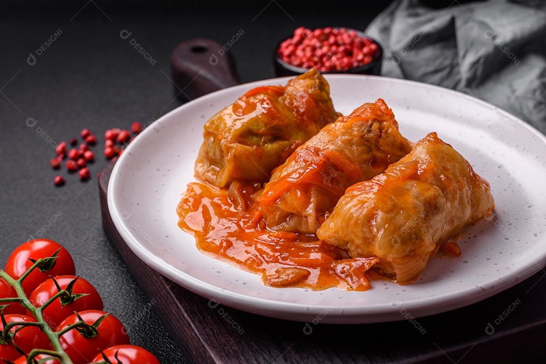 Delicioso dolma em molho de tomate com cenoura, cebola, sal, especiarias e ervas sobre um fundo escuro de concreto