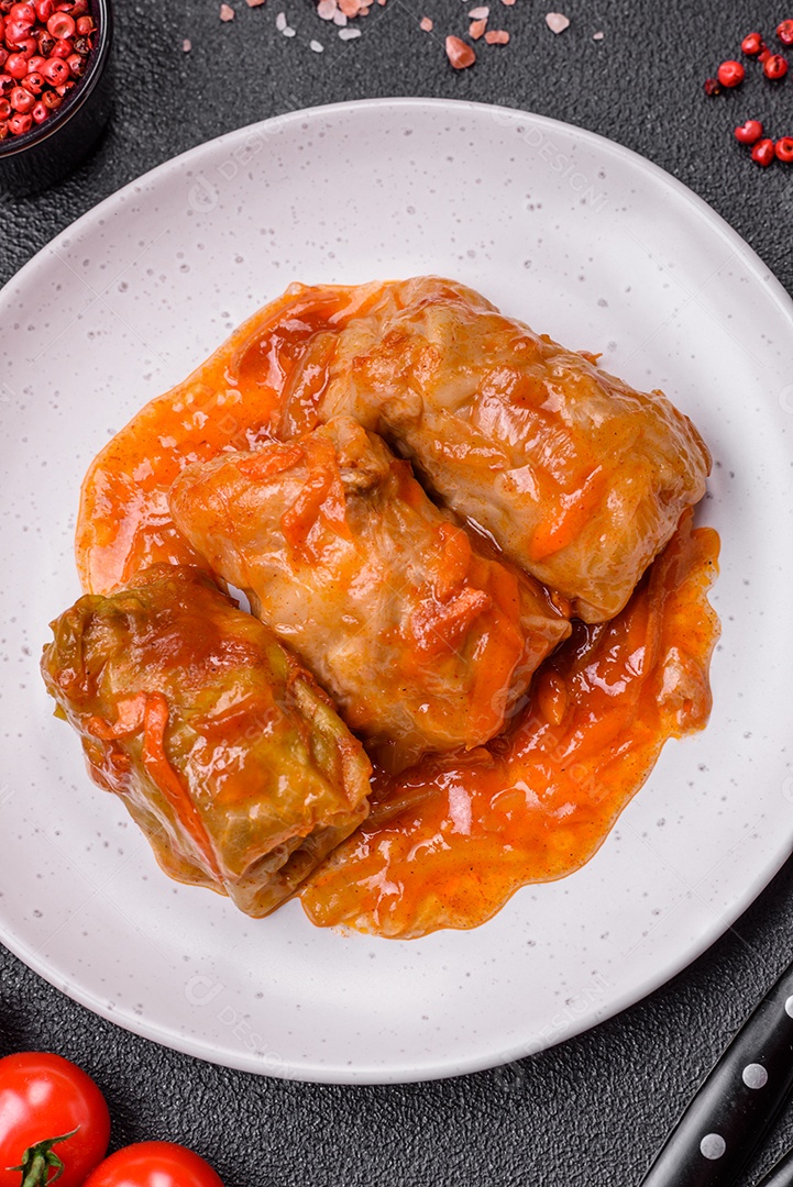 Delicioso dolma em molho de tomate com cenoura, cebola, sal, especiarias e ervas sobre um fundo escuro de concreto