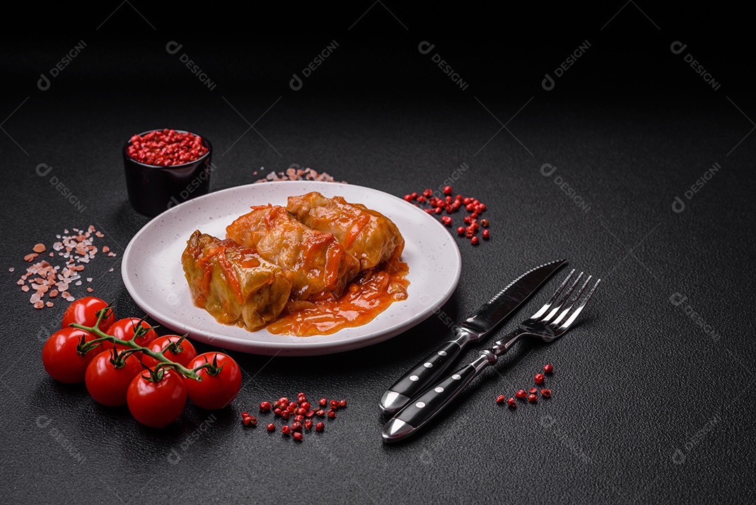 Delicioso dolma em molho de tomate com cenoura, cebola, sal, especiarias e ervas sobre um fundo escuro de concreto
