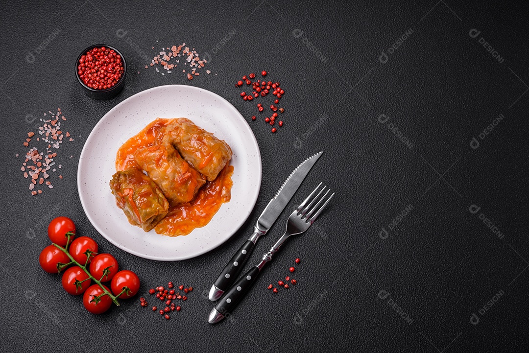 Delicioso dolma em molho de tomate com cenoura, cebola, sal, especiarias e ervas sobre um fundo escuro de concreto