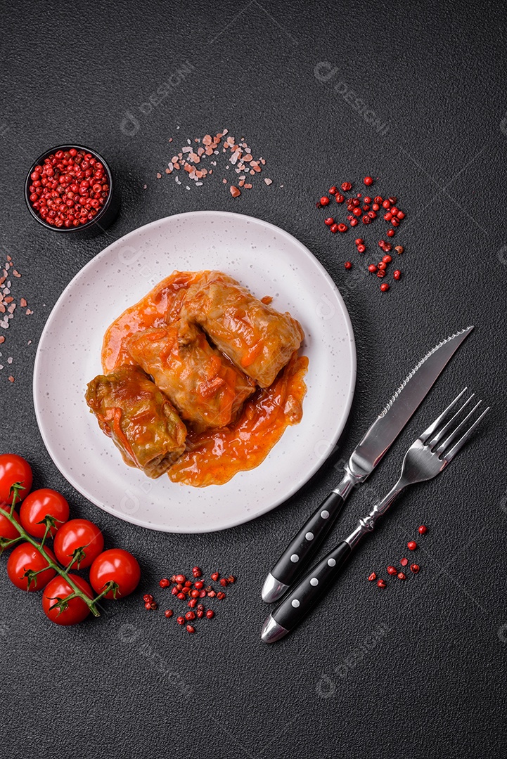 Delicioso dolma em molho de tomate com cenoura, cebola, sal, especiarias e ervas sobre um fundo escuro de concreto