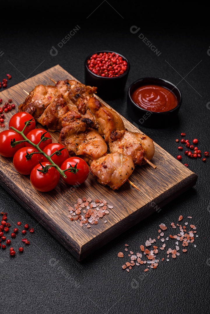 Delicioso frango fresco e suculento ou kebab de porco em espetos com sal e especiarias sobre um fundo escuro de concreto