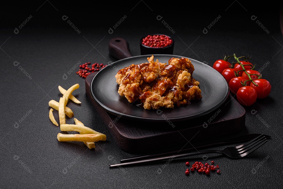 Deliciosas mordidas suculentas de carne de frango grelhado com sal, especiarias e ervas em um fundo escuro de concreto