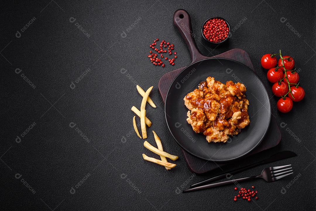 Deliciosas mordidas suculentas de carne de frango grelhado com sal, especiarias e ervas em um fundo escuro de concreto