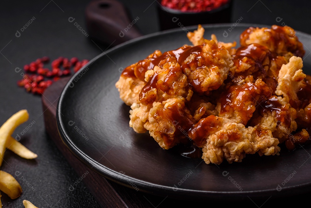 Deliciosas mordidas suculentas de carne de frango grelhado com sal, especiarias e ervas em um fundo escuro de concreto